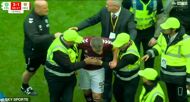 Hearts condemn ugly scenes that saw Celtic fans ATTACK their players: Scottish club call for ‘the strongest action possible’ with police investigating after their captain was PUNCHED by pitch invader